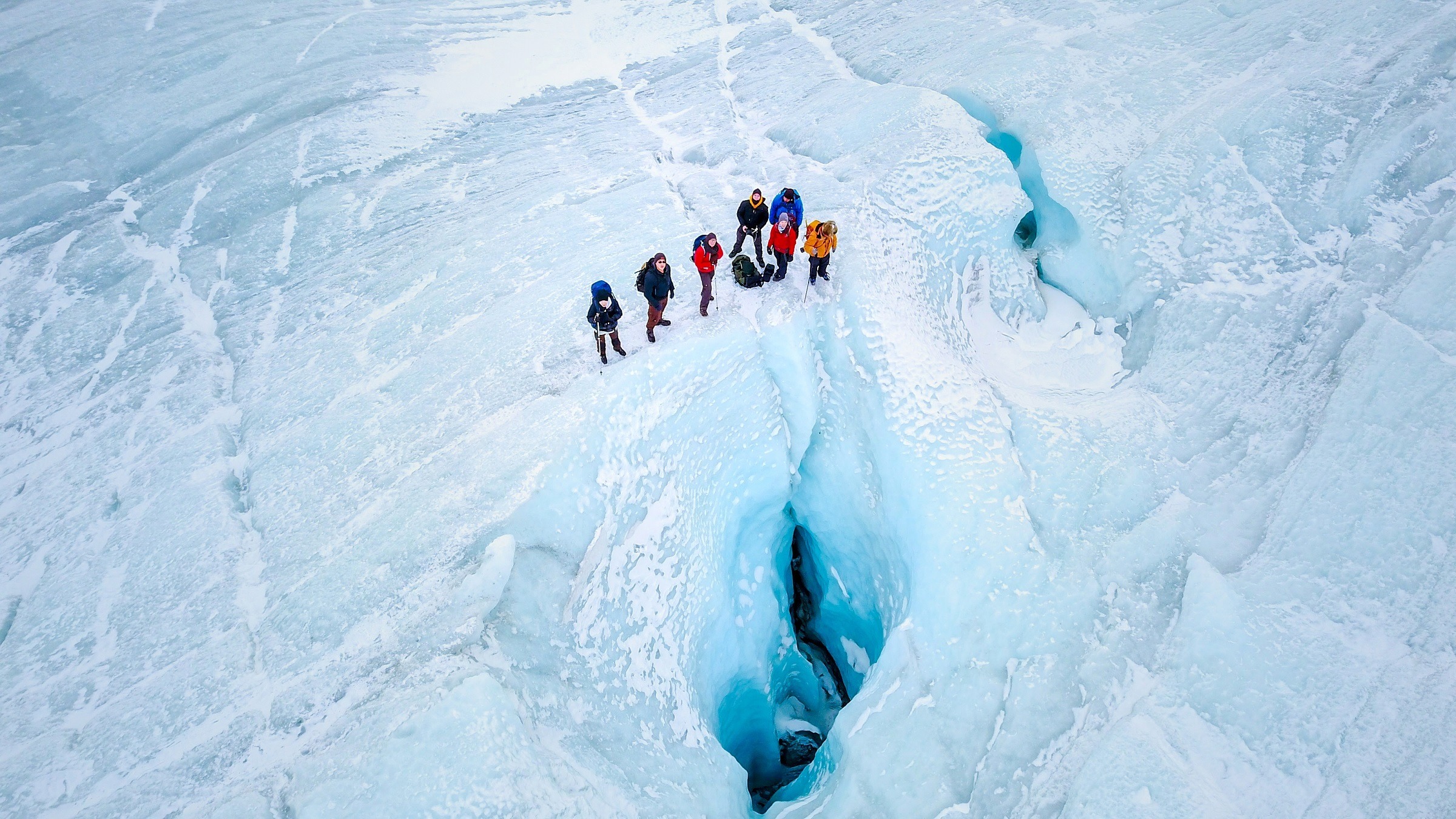 Drone photograph of people near a moulin on the Greenland Ice Sheet near Kangerlussuaq